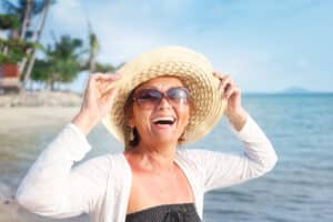 Woman with cataracts wearing sunglasses to protect her eyes on the beach